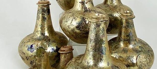 After being discovered by accident at a construction site, a hoard of gold-encrusted 17th century wine bottles is scheduled to go to auction with a guide price of £20,000.